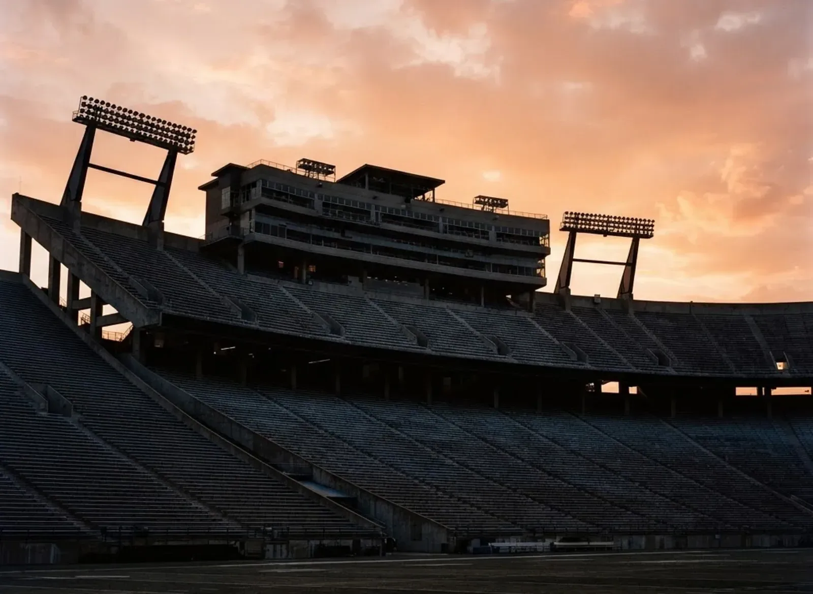 Empty college stadium grandstands and press box at sunset